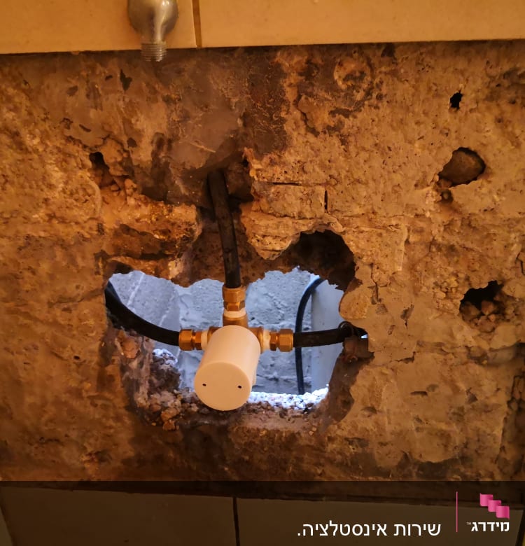 צינור מים עם מחבר בקיר חשוף